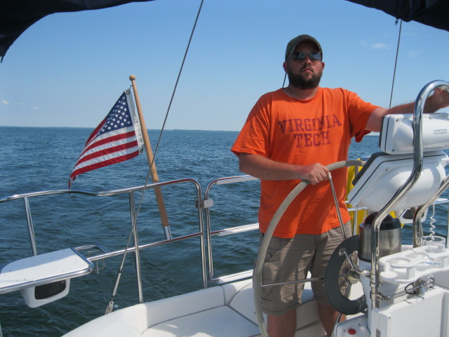 A young man behind the wheel, sailing