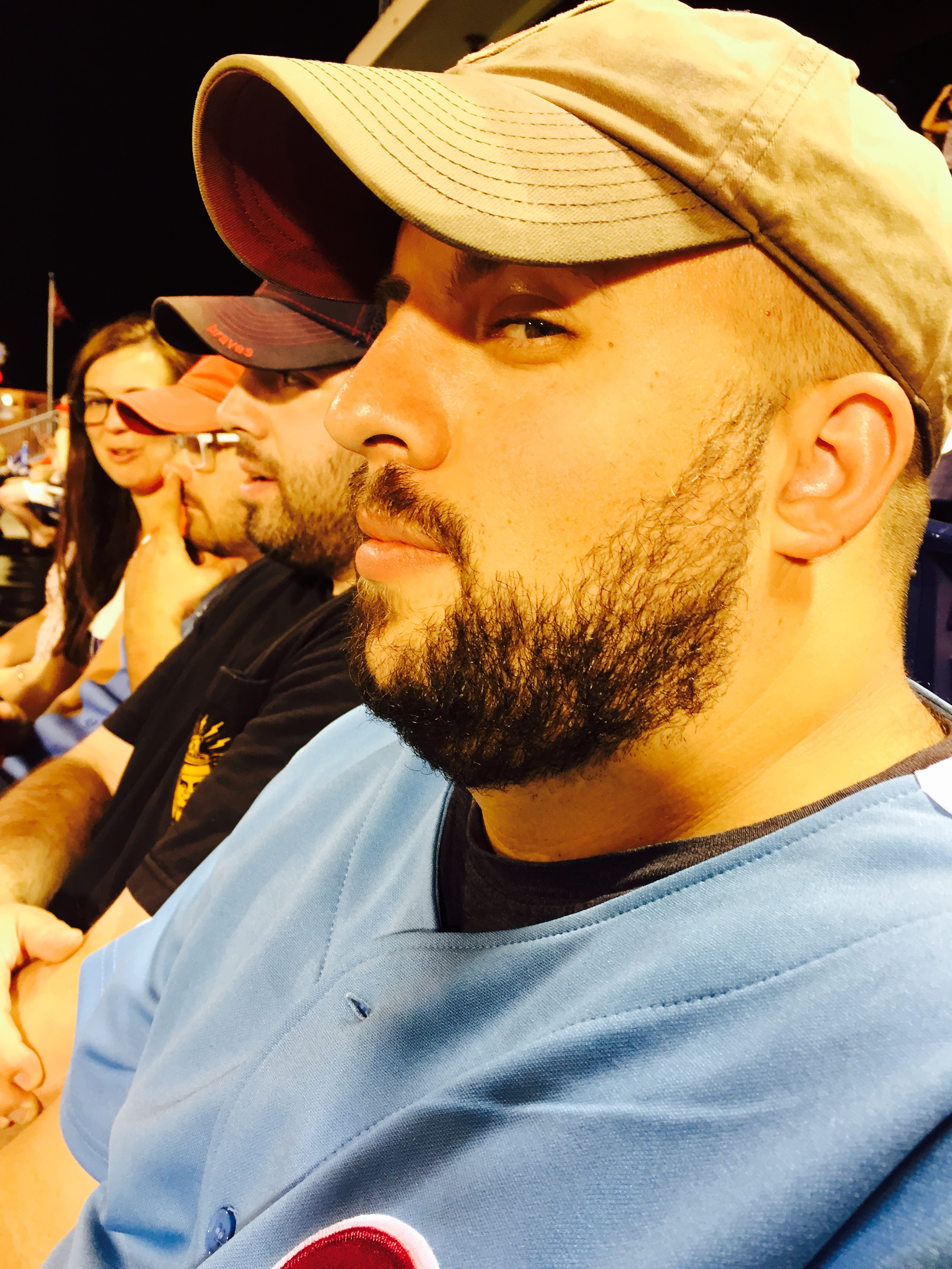 Side profile of a man, sitting in a row of people