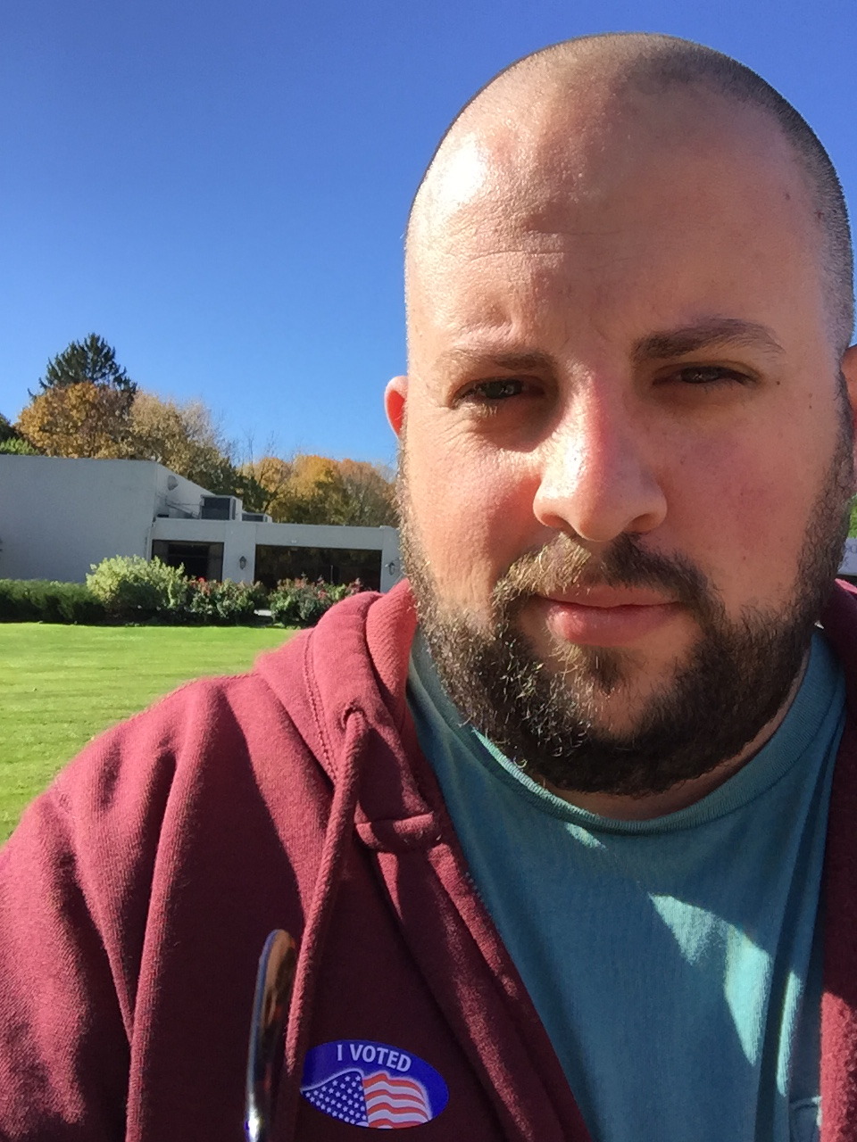 A close up of a man with a "I Voted" sticker on his shirt