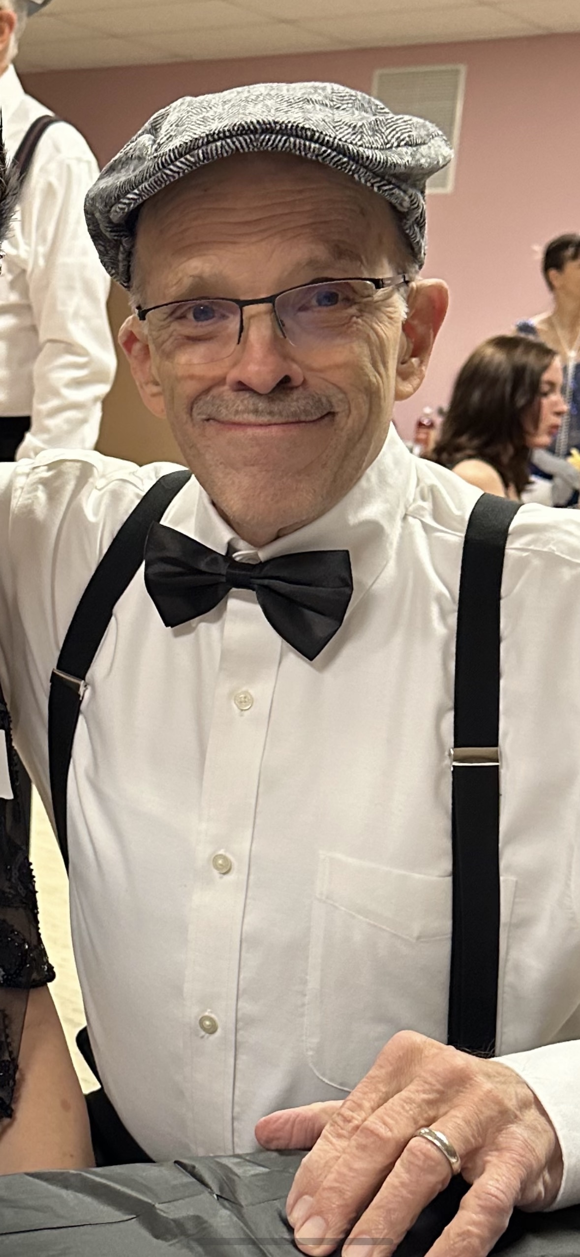 An older gentleman wearing a hat and fancy bowtie